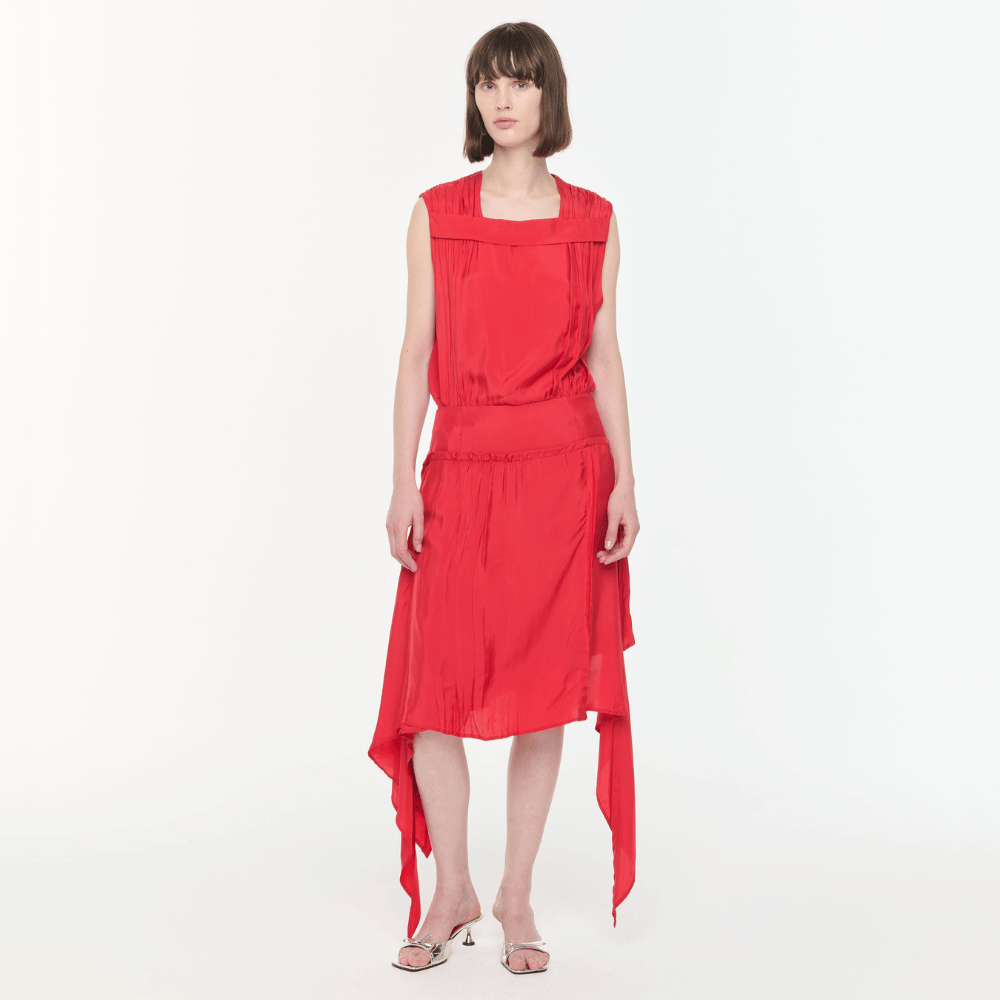 Plan C Asymmetric Viscose Skirt in Fire Red styled on model with draped asymmetric hem front view