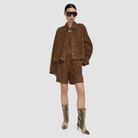 Model wearing the JOSEPH Aitna suede jacket in taupe over matching suede shorts, full length