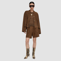 Model wearing the JOSEPH Aitna light suede jacket in taupe with snake-print boots, full length