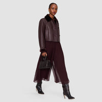 Model walking in the JOSEPH Ale wide-leg silk chiffon trousers in mahogany, showing the fluid leg