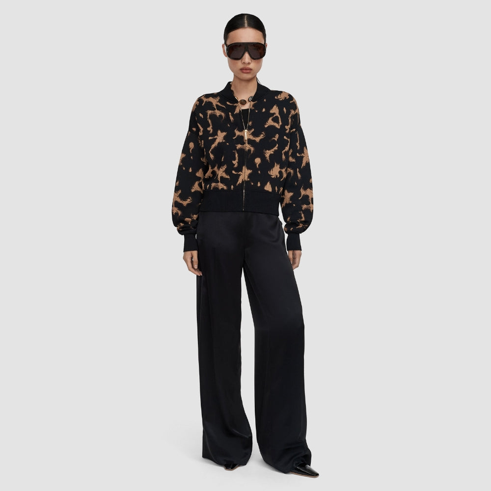 Model wearing the JOSEPH Ambra tortoiseshell knit bomber with black wide-leg trousers, full length