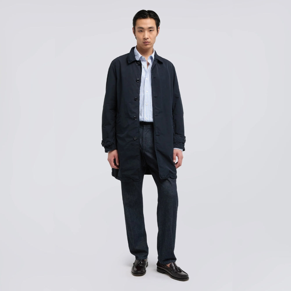 Aspesi light blue striped cotton shirt worn by a model under a navy coat with dark jeans and loafers