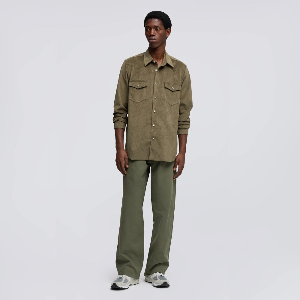 Aspesi West Alcantara shirt in olive worn by a model with sleeves rolled, green trousers and grey sneakers