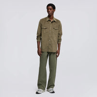 Aspesi West Alcantara shirt in olive worn by a model with sleeves rolled, green trousers and grey sneakers