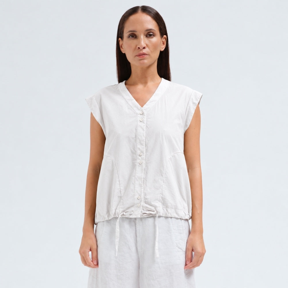 A white cotton shirt by Transit Par Such with a collarless V-neck, button front, cap sleeves and a drawstring hem for a boxy, cropped shape - front view
