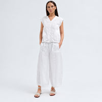 A white cotton shirt by Transit Par Such with a collarless V-neck, button front, cap sleeves and a drawstring hem for a boxy, cropped shape - full model front view