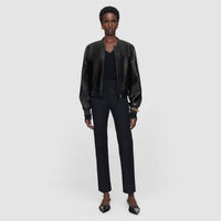 Model wearing the JOSEPH Coleman Long black trousers with a leather bomber jacket, full length