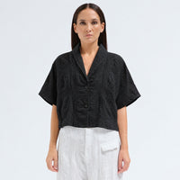 A boxy, cropped kimono jacket by Transit Par Such in black embossed cotton and linen jacquard, with a shawl collar and wide short sleeves - front view