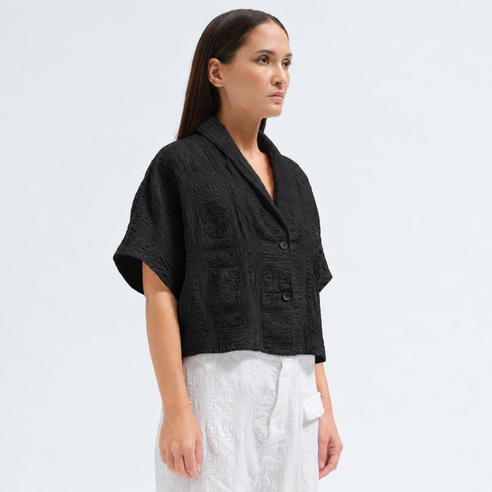 A boxy, cropped kimono jacket by Transit Par Such in black embossed cotton and linen jacquard, with a shawl collar and wide short sleeves - angle view