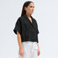 A boxy, cropped kimono jacket by Transit Par Such in black embossed cotton and linen jacquard, with a shawl collar and wide short sleeves - angle view