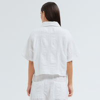 A boxy, cropped kimono jacket by Transit Par Such in white embossed cotton and linen jacquard, with a shawl collar and wide short sleeves - back view