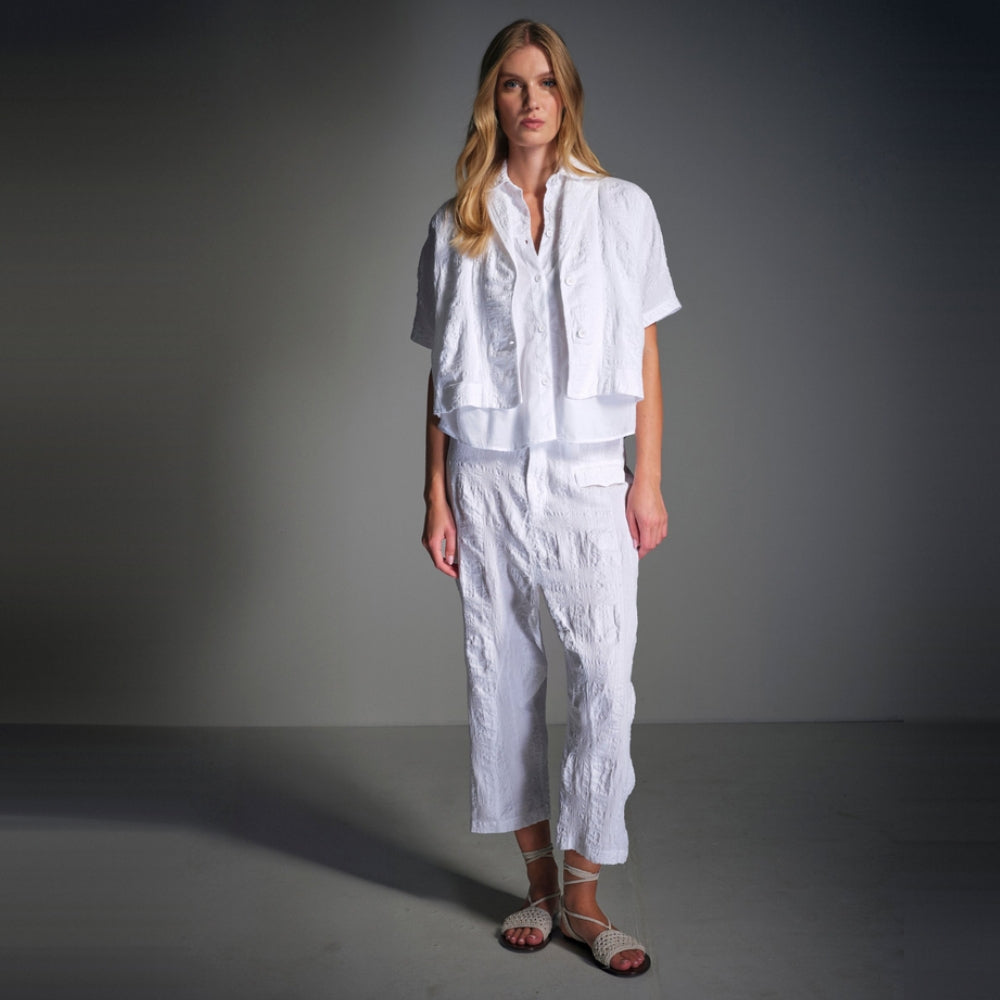 A boxy, cropped kimono jacket by Transit Par Such in white embossed cotton and linen jacquard, with a shawl collar and wide short sleeves - model campaign studio view
