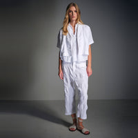 A boxy, cropped kimono jacket by Transit Par Such in white embossed cotton and linen jacquard, with a shawl collar and wide short sleeves - model campaign studio view