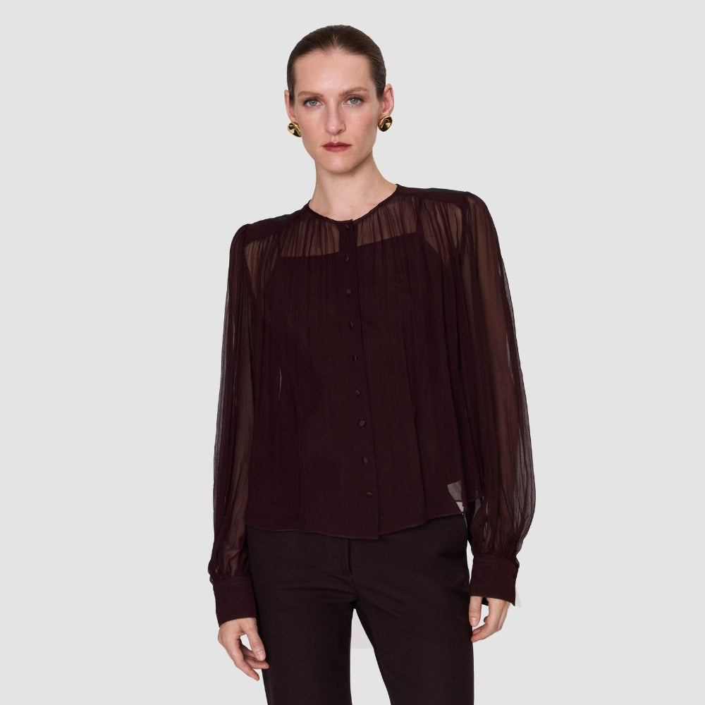 Model wearing the JOSEPH Elisa sheer silk chiffon blouse in mahogany over its camisole
