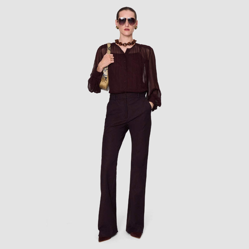 Model wearing the JOSEPH Elisa silk chiffon blouse in mahogany with tonal flared trousers, full length