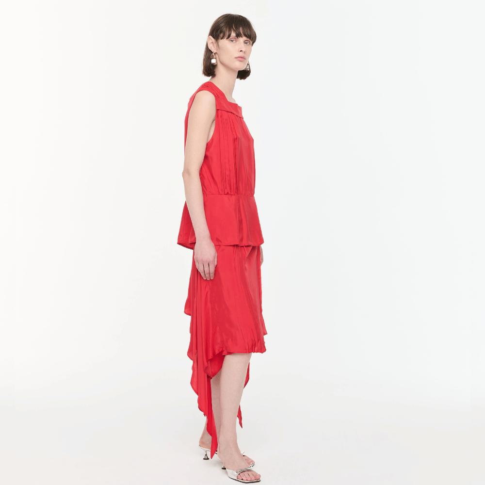 Plan C Asymmetric Viscose Skirt in Fire Red styled on model with draped asymmetric hem - side view