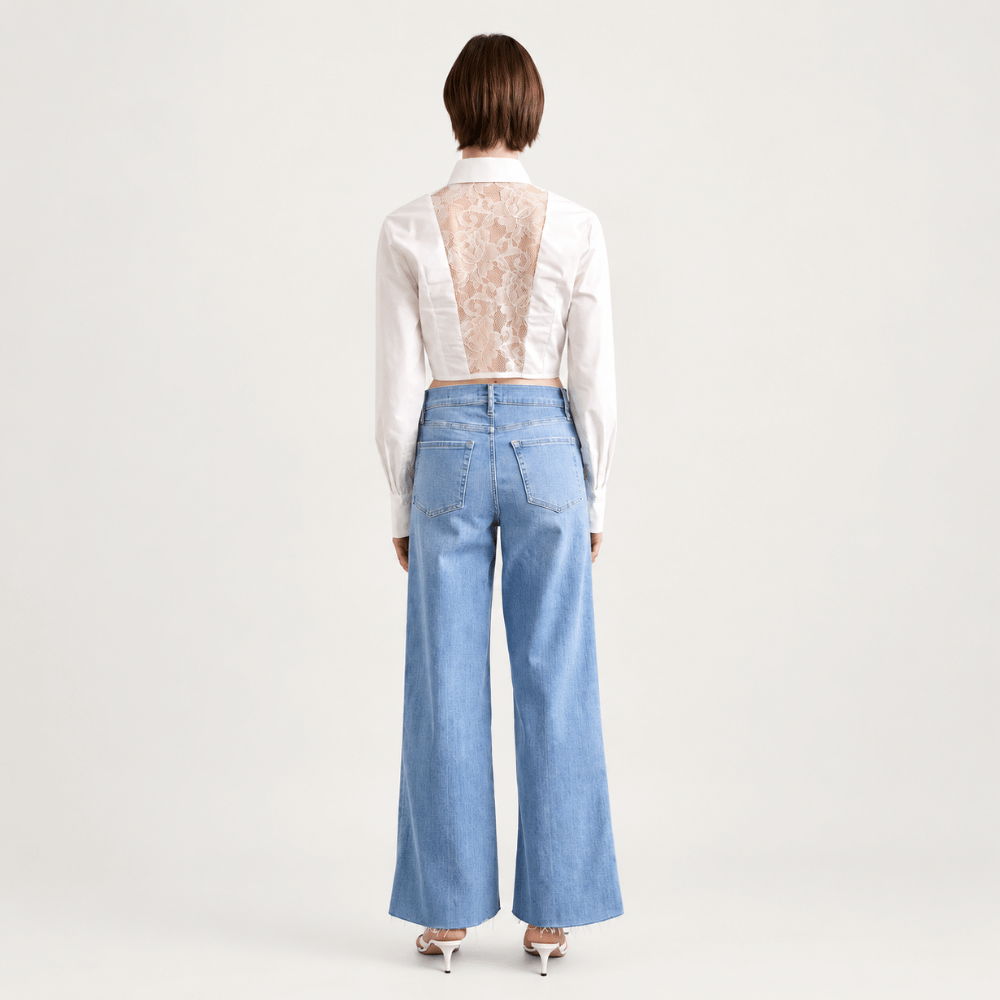 Model back view - FRAME Le Slim Palazzo Raw Fray Jeans in Clearwater at Riada Concept. High-rise, light-blue wide-leg stretch denim. Shop Australia-wide or in Sydney.
