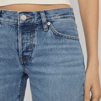Close-up of FRAME The Gray Jean in Rapture at Riada Concept. Low-rise rigid denim with a long wide-leg flare, button fly and 34-inch inseam - showing the front waistband, button, belt loop, and pocket.