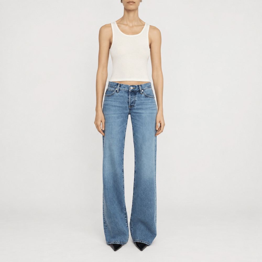 FRAME The Gray Jean in Rapture at Riada Concept. Low-rise rigid denim with a long wide-leg flare, button fly and 34-inch inseam - styled model view