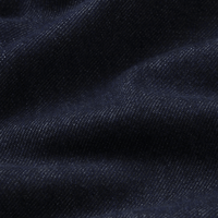 A close-up of dark navy blue fabric with a fine textured weave and soft folds. FRAME The Hang Jeans in Rinse at Riada Concept. Mid-rise ankle-length straight jeans in rigid regenerative cotton denim- front view