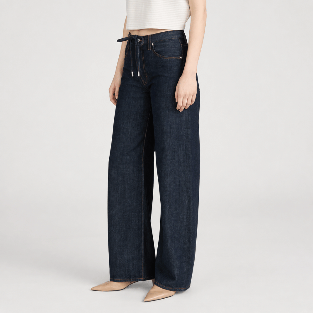 FRAME The Off Duty Drawstring Bow Jeans in Rinse at Riada Concept. High-rise fluid denim with a curved leg and drawstring waist - angle view