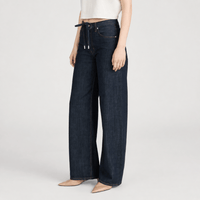 FRAME The Off Duty Drawstring Bow Jeans in Rinse at Riada Concept. High-rise fluid denim with a curved leg and drawstring waist - angle view