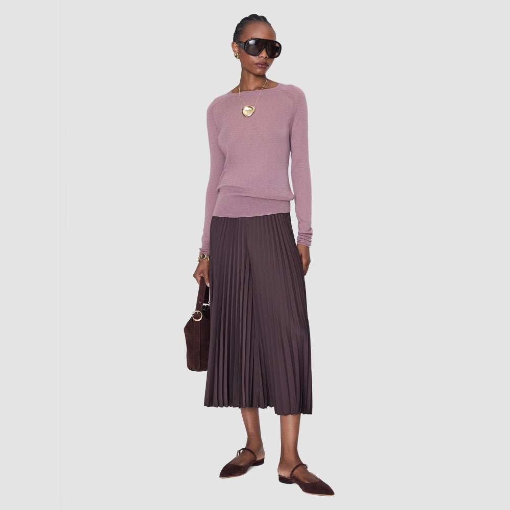 Model wearing the JOSEPH Geras cashmere jumper in lilac with a pleated midi skirt, full length