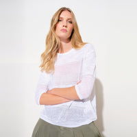 An oversized white jacquard knit by Transit Par Such with a round neck, dropped shoulders, elbow-length sleeves and semi-sheer openwork stripes - studio model view