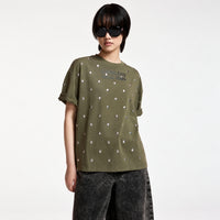 Riada Concept Essentiel Antwerp Kourse T-shirt in khaki organic cotton, scattered with silver-tone studs and printed with slogans on the front and back. Relaxed fit - model front view cropped