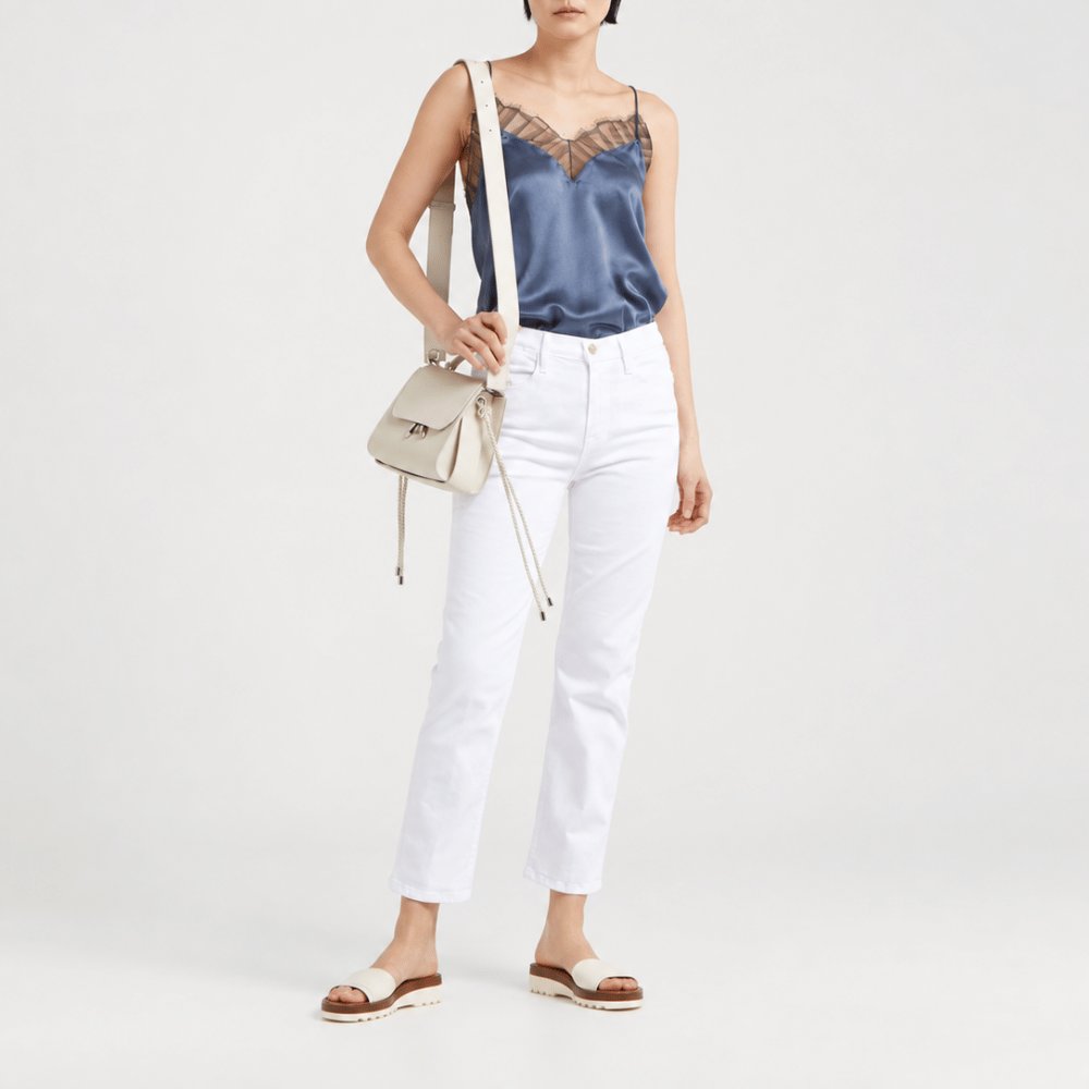 FRAME Le High Straight Cropped Jeans in Blanc at Riada Concept. High-rise slim straight white denim with strong stretch recovery - front view styled model