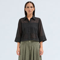 A boxy, cropped black shirt by Transit Par Such in stretch poplin with sheer panels, a pointed collar and three-quarter sleeves with wide cuffs - front view