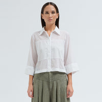 A boxy, cropped black shirt by Transit Par Such in stretch poplin with sheer panels, a pointed collar and three-quarter sleeves with wide cuffs - front view