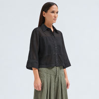 A boxy, cropped black shirt by Transit Par Such in stretch poplin with sheer panels, a pointed collar and three-quarter sleeves with wide cuffs - angle view