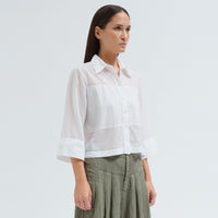 A boxy, cropped black shirt by Transit Par Such in stretch poplin with sheer panels, a pointed collar and three-quarter sleeves with wide cuffs - side view