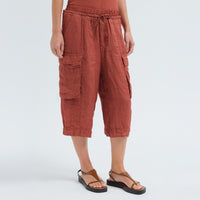 Wide linen cargo Bermuda shorts by Transit Par Such in brick, falling below the knee, with flap cargo pockets and a drawstring elastic waist - angle view