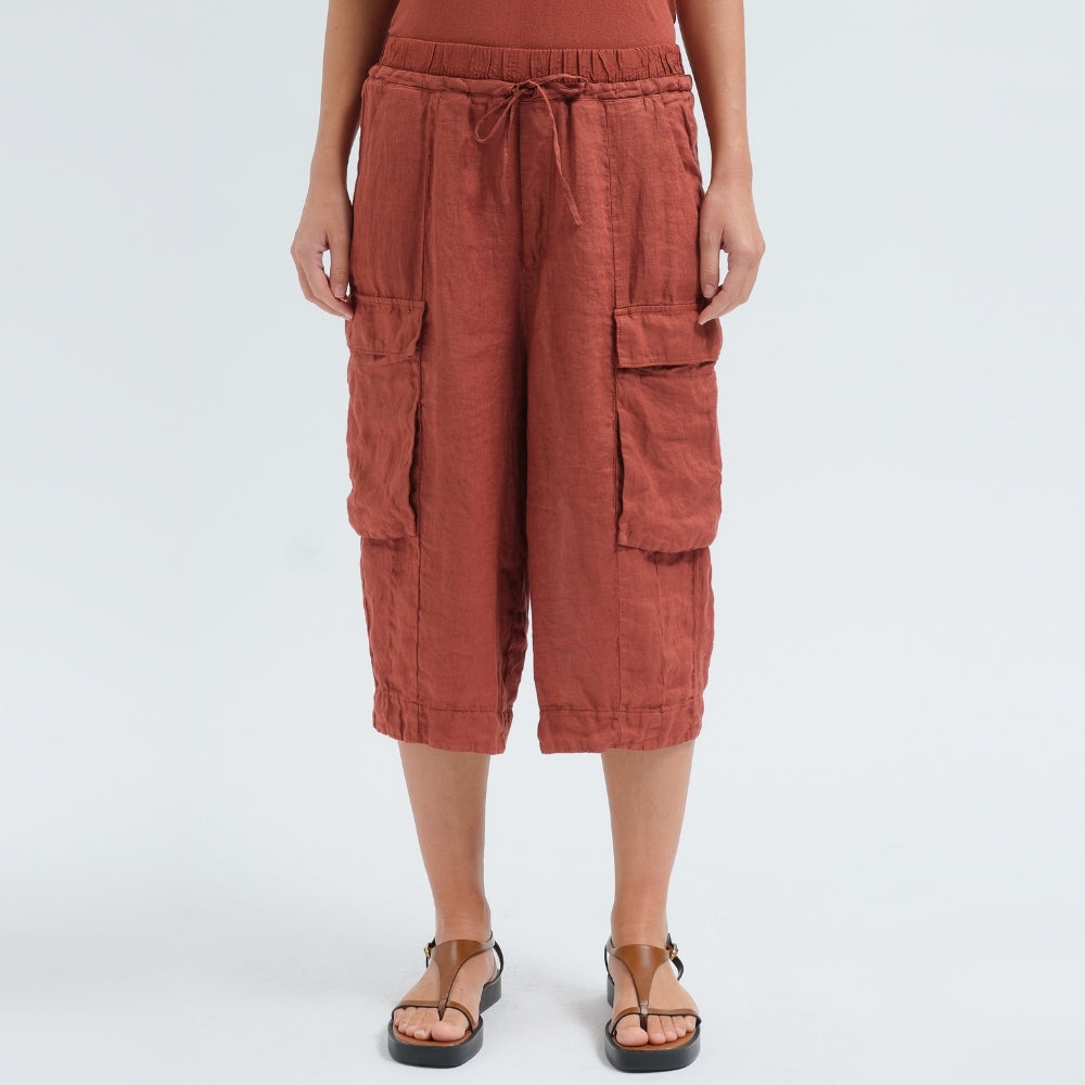 Wide linen cargo Bermuda shorts by Transit Par Such in brick, falling below the knee, with flap cargo pockets and a drawstring elastic waist - front view