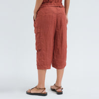 Wide linen cargo Bermuda shorts by Transit Par Such in brick, falling below the knee, with flap cargo pockets and a drawstring elastic waist - back view