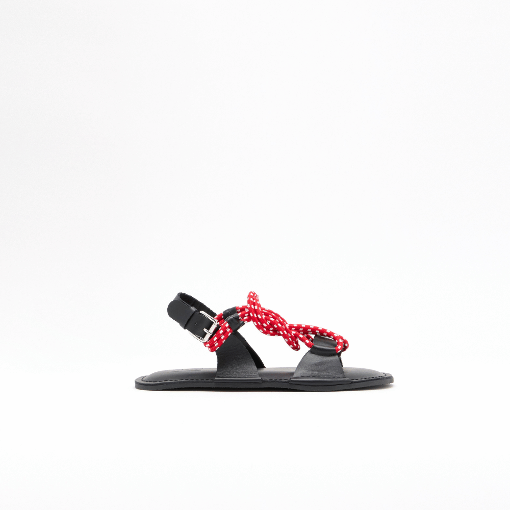 Plan C black leather flat sandal side view with red and white cord detail