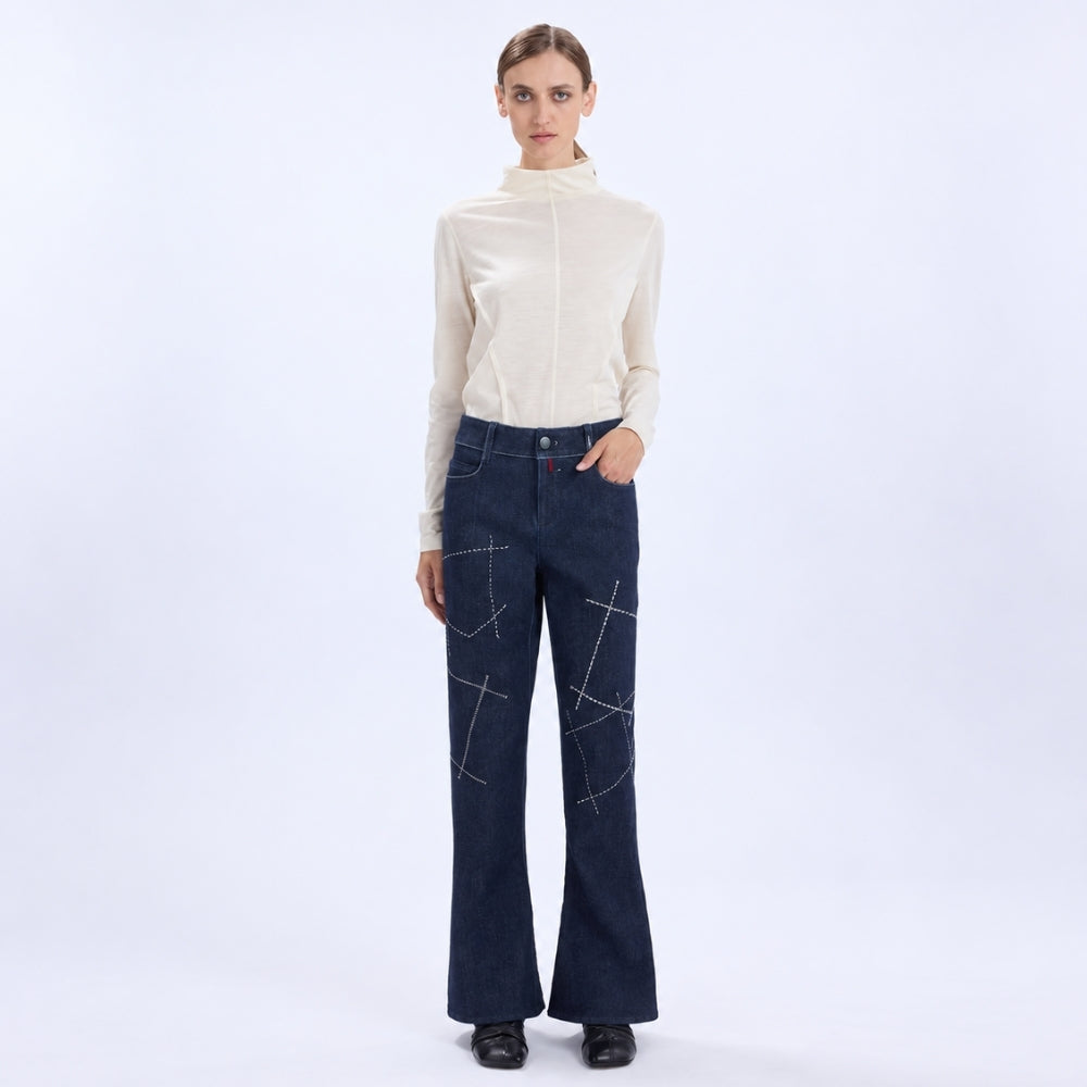 HIGH Everyday Couture Stardom bootcut jeans in deep blue denim with off-white geometric embroidery, front view