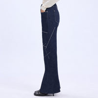 HIGH Everyday Couture Stardom bootcut jeans in deep blue denim with off-white geometric embroidery, left side view