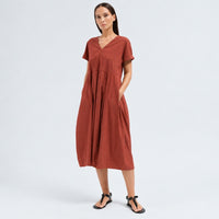 A below-the-knee V-neck dress by Transit Par Such in brick stretch cotton, with a high-cut waist, cuffed short sleeves and side pockets - front pocket view