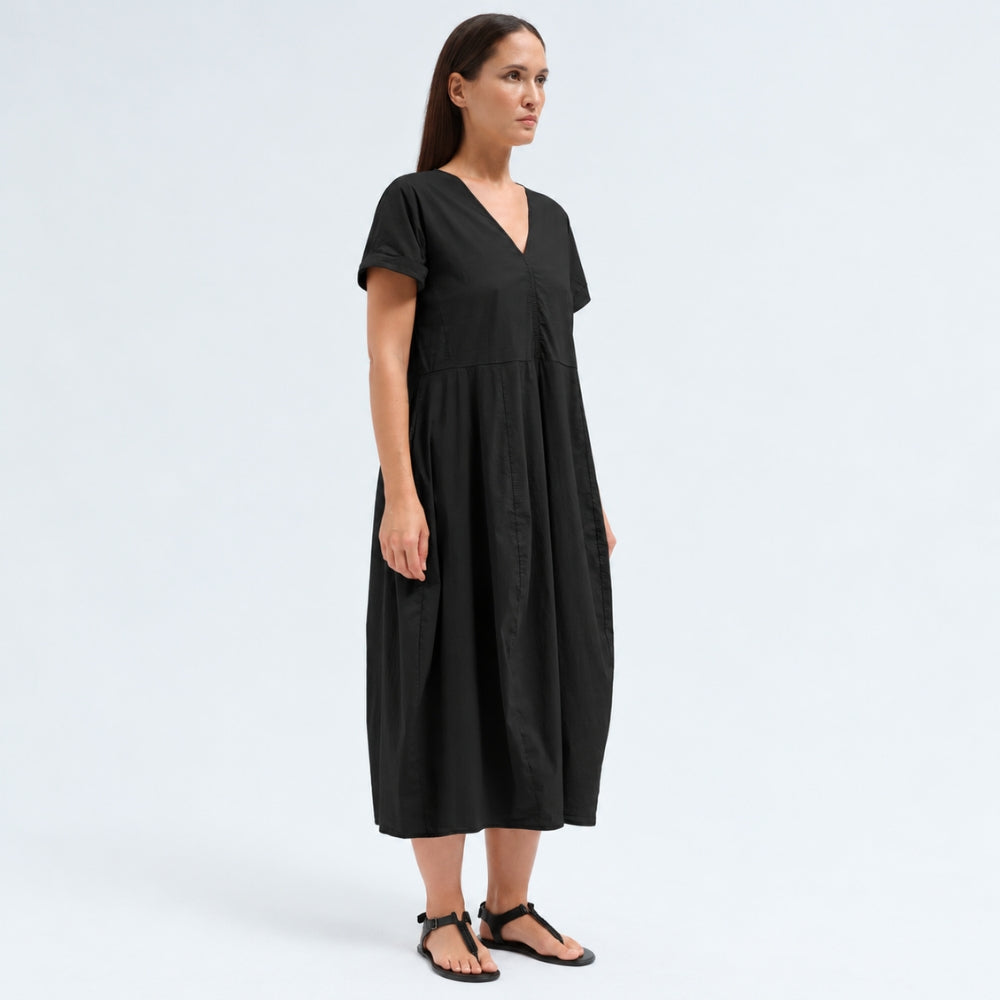 A below-the-knee V-neck dress by Transit Par Such in black stretch cotton, with a high-cut waist, cuffed short sleeves and side pockets - side view