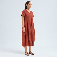A below-the-knee V-neck dress by Transit Par Such in brick stretch cotton, with a high-cut waist, cuffed short sleeves and side pockets - angle view