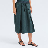 A flared midi skirt by Transit Par Such in petrol striped linen and cupro, with a drawstring waist, button detail at the front and slant pockets - angle view