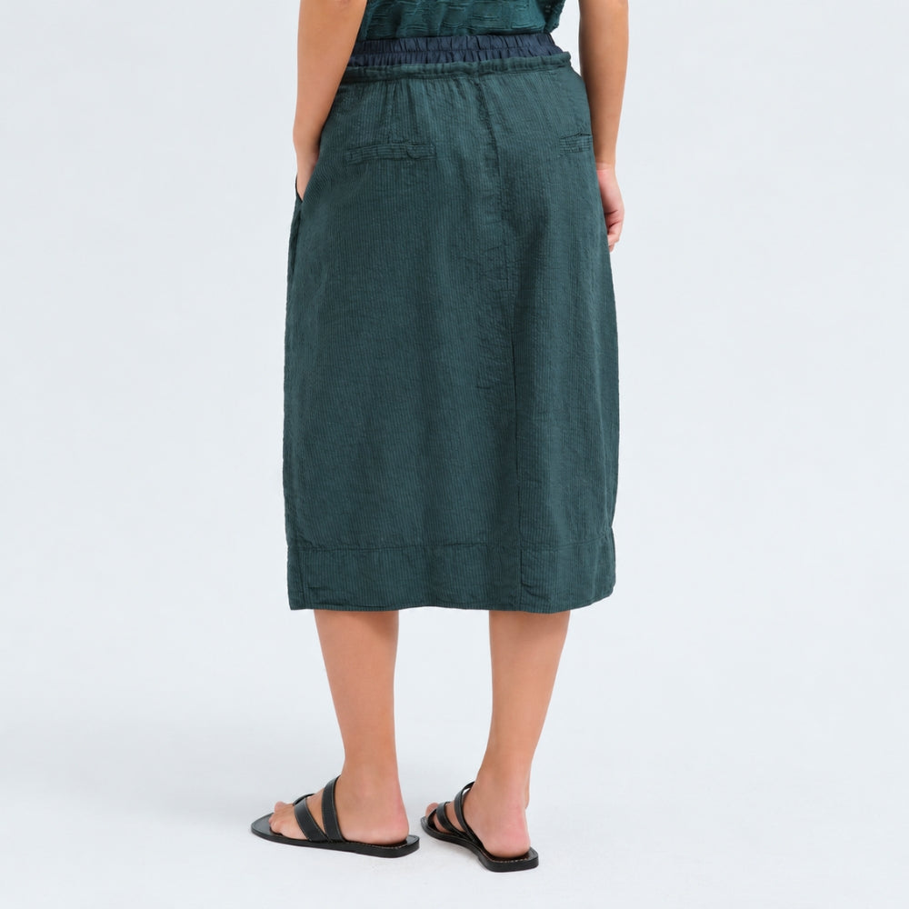 A flared midi skirt by Transit Par Such in petrol striped linen and cupro, with a drawstring waist, button detail at the front and slant pockets - back view