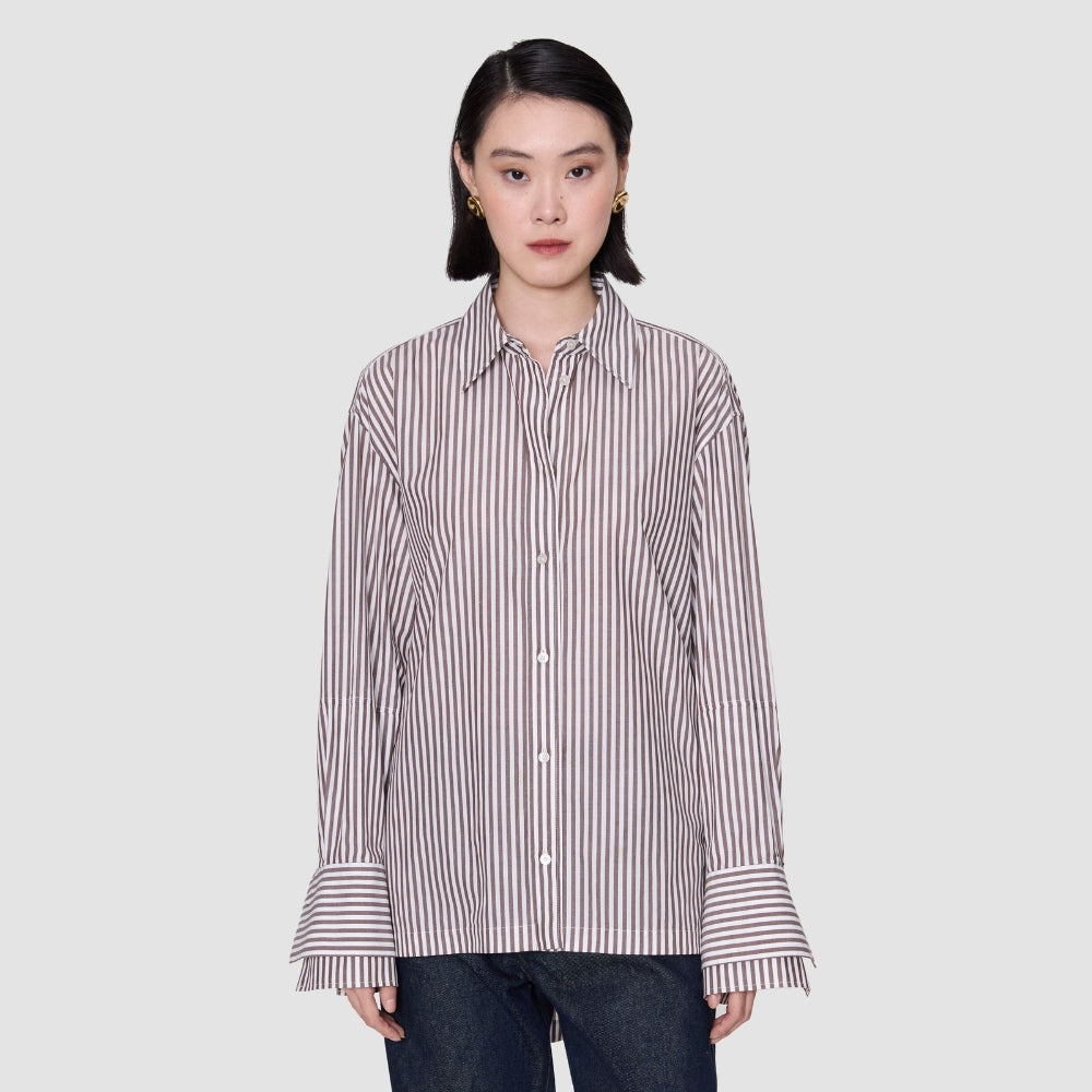 Model wearing the JOSEPH Theia oversized stripe shirt buttoned, with the double cuffs turned back