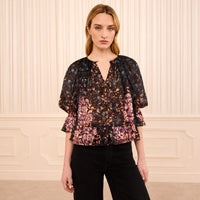 Riada Concept Ulla Johnson Elise silk jacquard blouse in a black floral bouquet print, with ruffles at the sleeves and hem - styled model