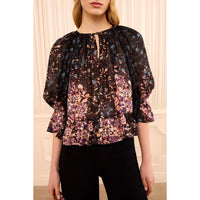 Riada Concept Ulla Johnson Elise silk jacquard blouse in a black floral bouquet print, with ruffles at the sleeves and hem - styled model - close front view