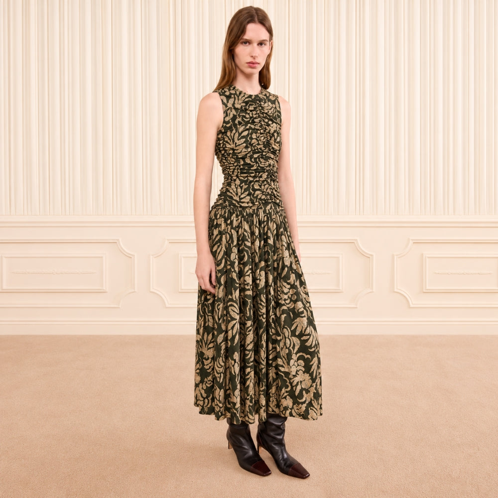 Riada Concept Ulla Johnson Elora sleeveless jersey dress in an olive floral print, with a ruched bodice and pleated skirt - styled model