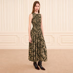Riada Concept Ulla Johnson Elora sleeveless jersey dress in an olive floral print, with a ruched bodice and pleated skirt - styled model